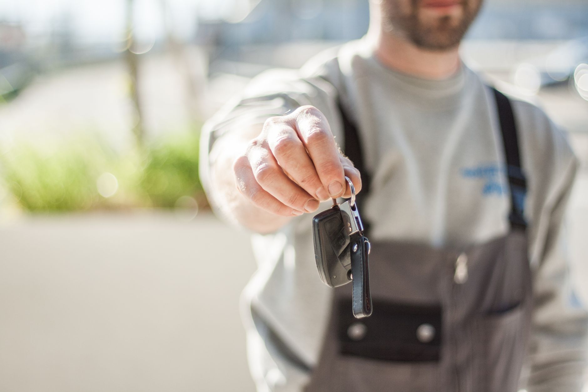 Locksmith consulting with a customer beside their car